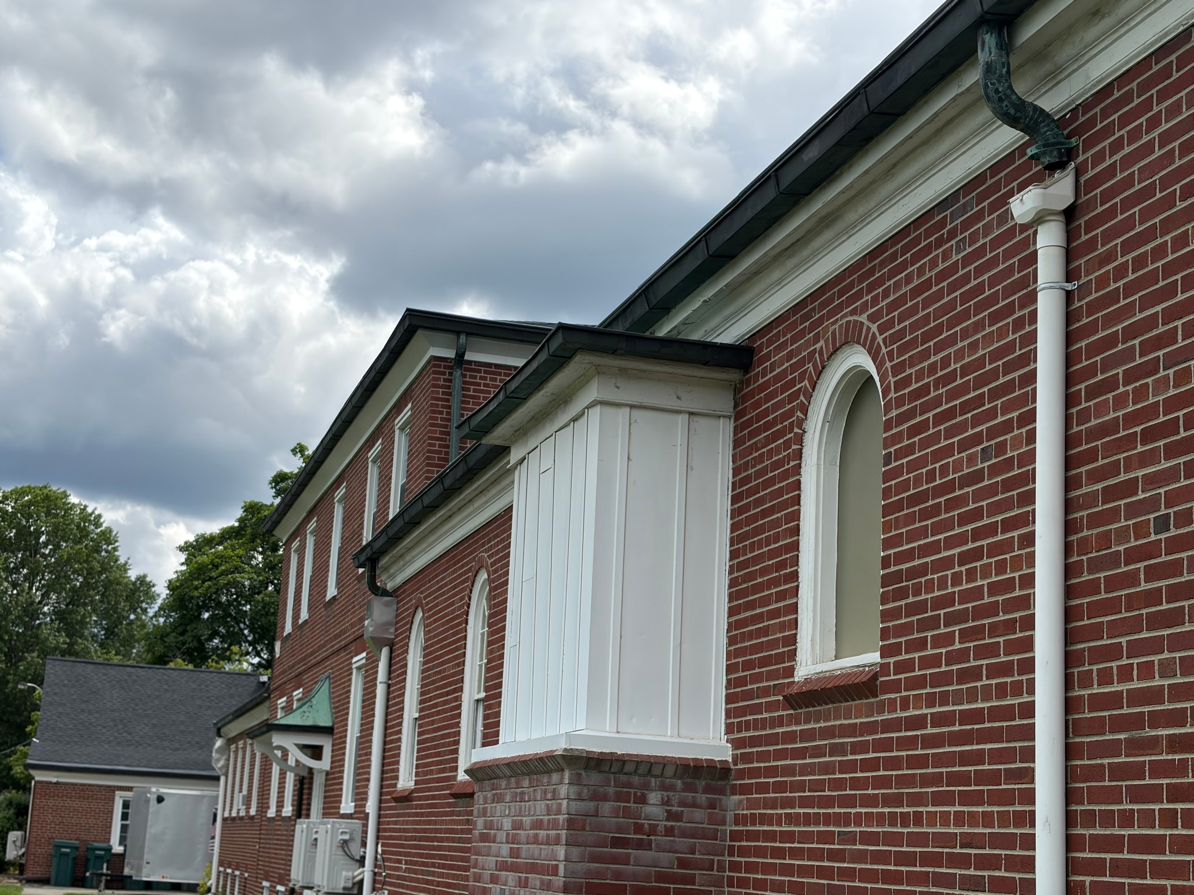 Full church exterior showing copper gutter system with steeple